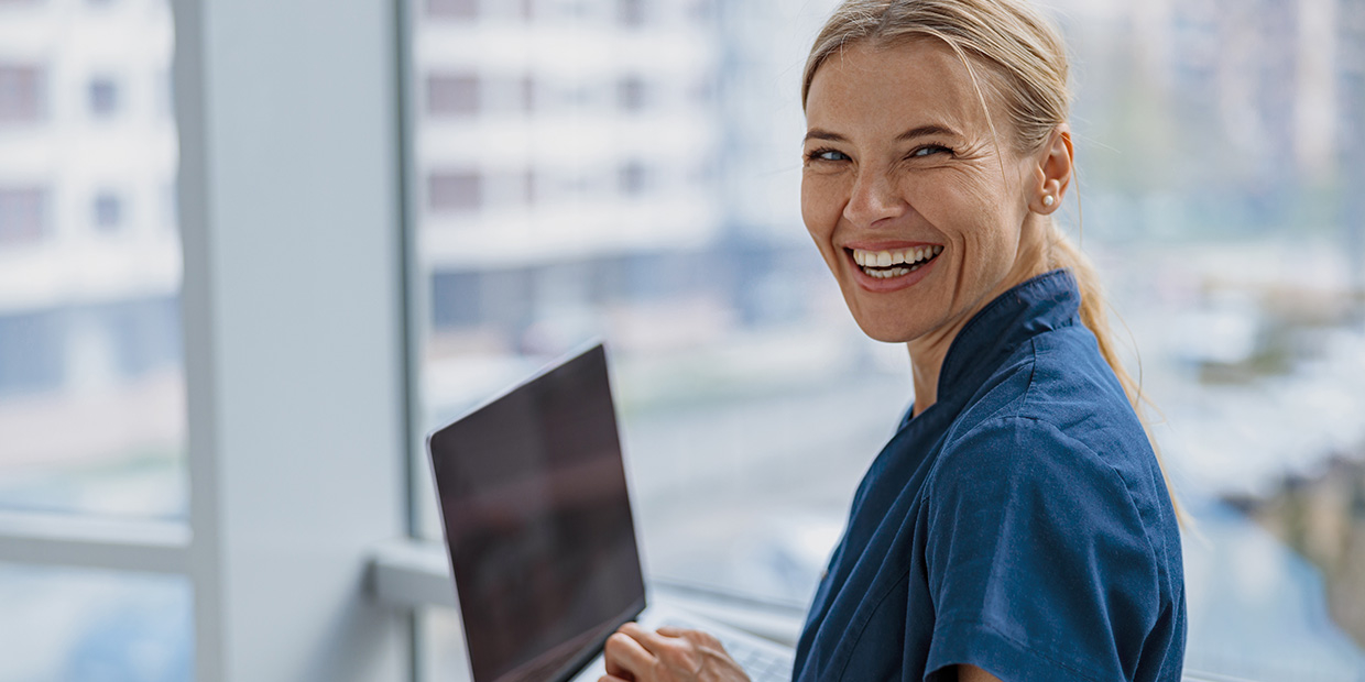 Lachende Frau mit Laptop im Arm